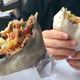 Hands holding burritos